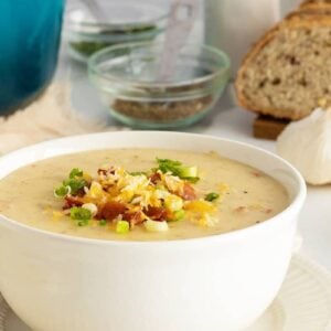 cream of potato soup in a white bowl with toppings