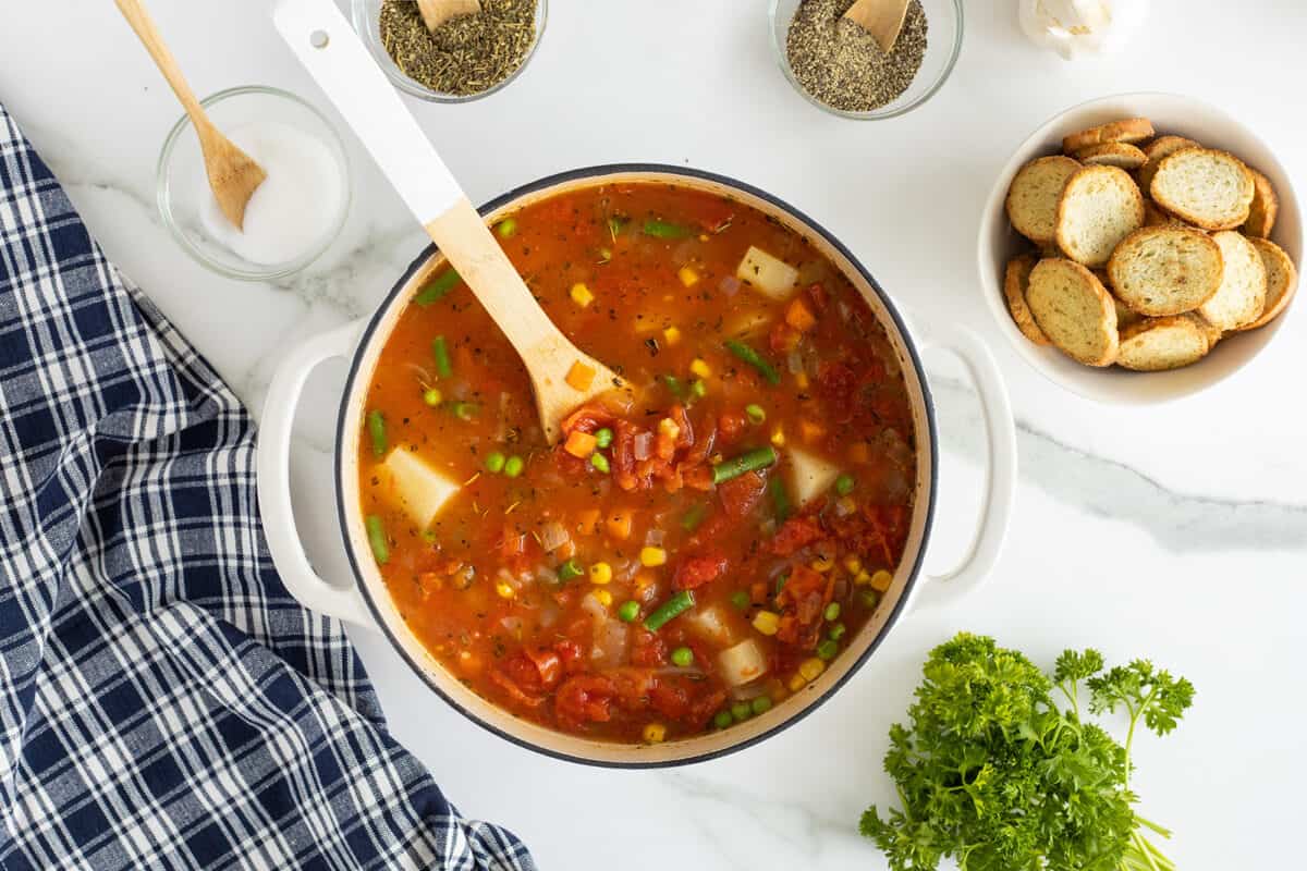 vegetable soup in a pot with a wooden spoon