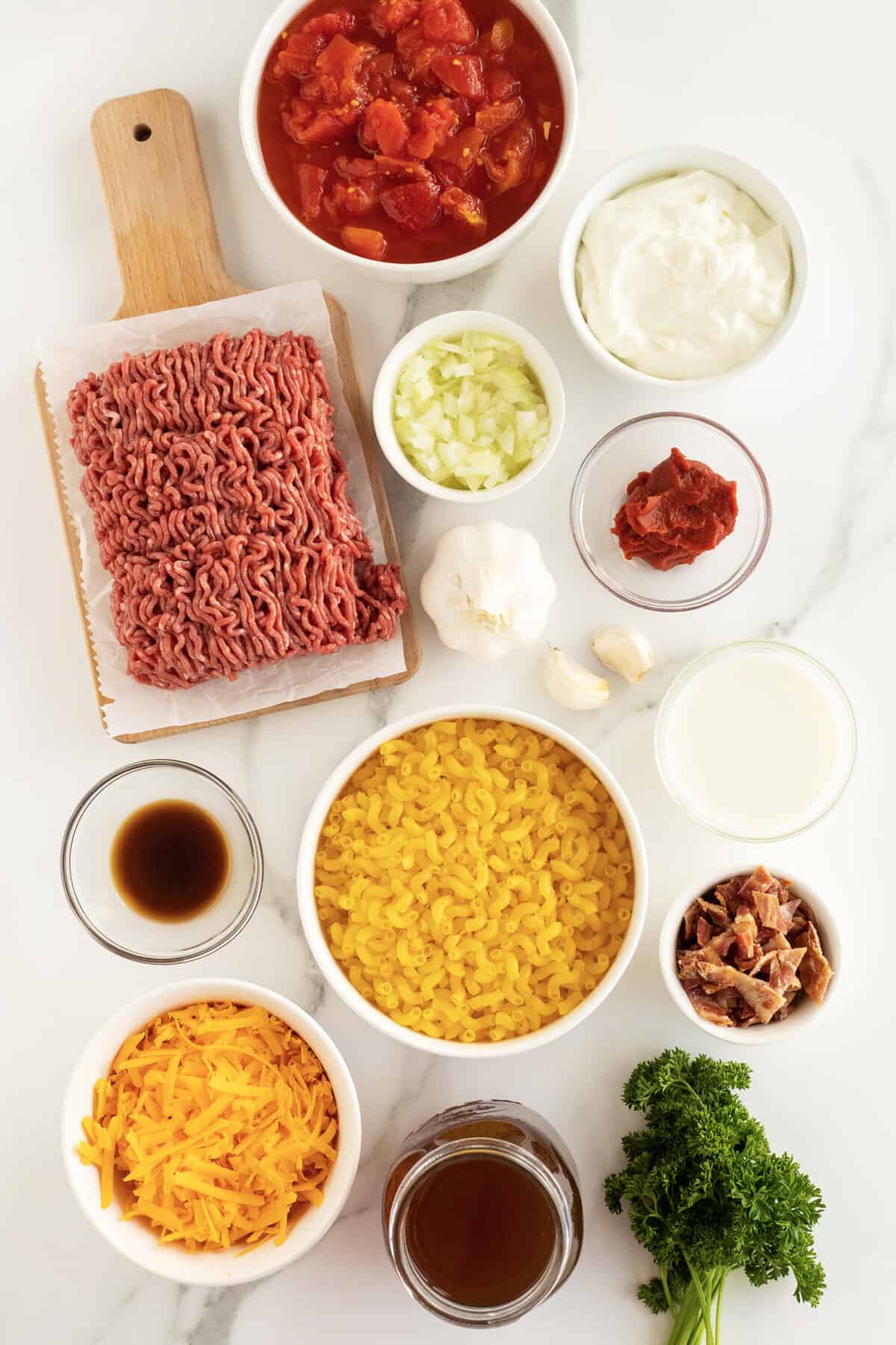 cheeseburger casserole ingredients in small white and clear bowls