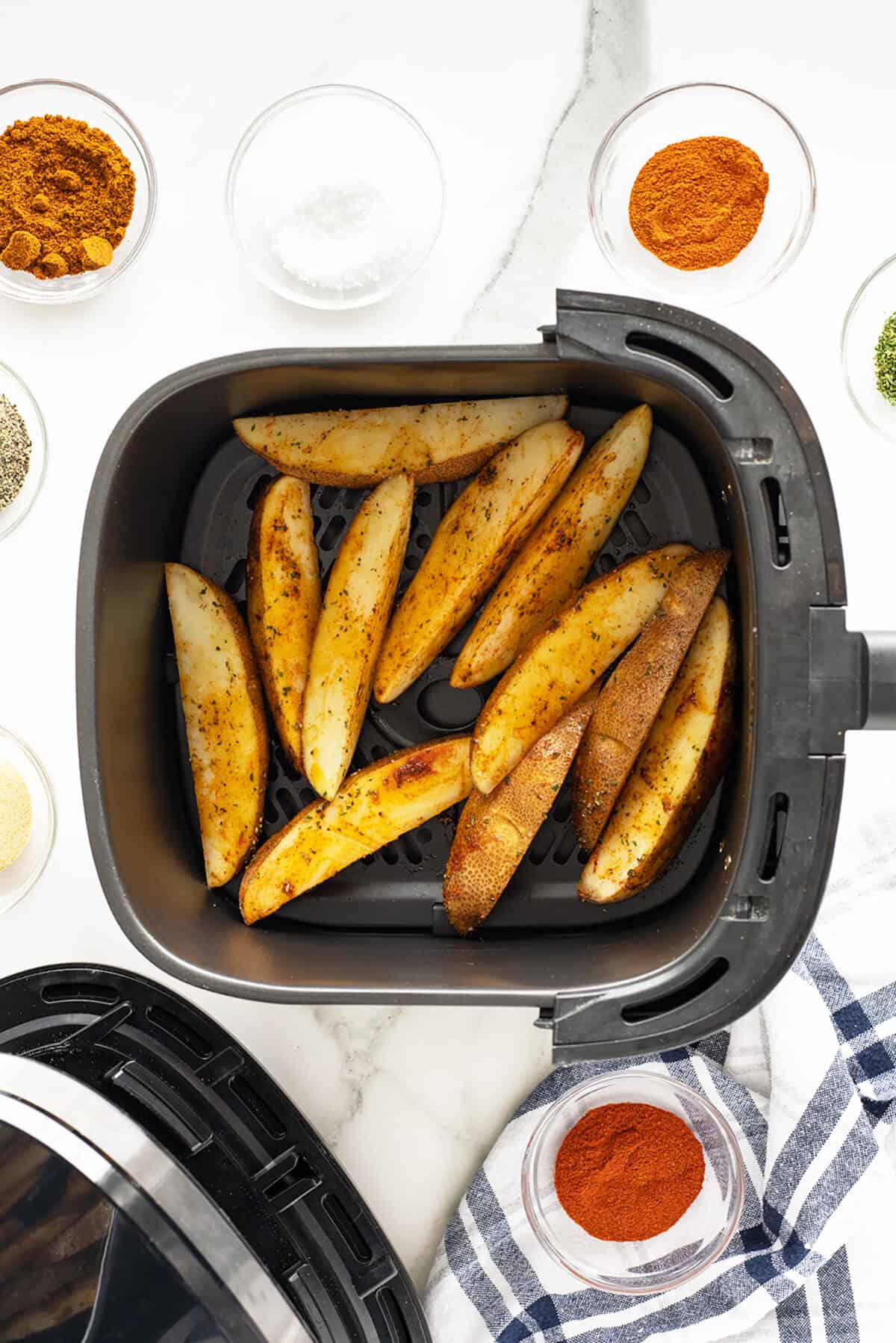 air fryer potato wedges prepared and in the basket of the air fryer