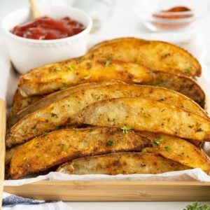 air fryer potato wedges on parchment paper in a dish