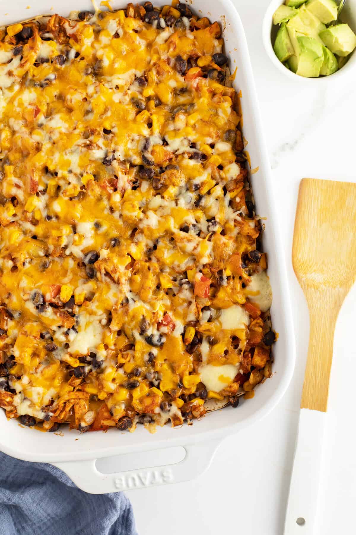 Chicken Enchilada Casserole baked in a white baking pan