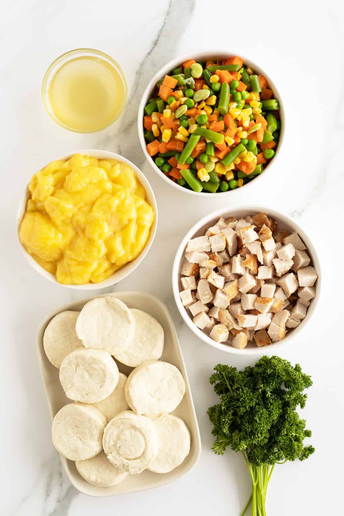chicken pot pie casserole ingredients in medium white bowls