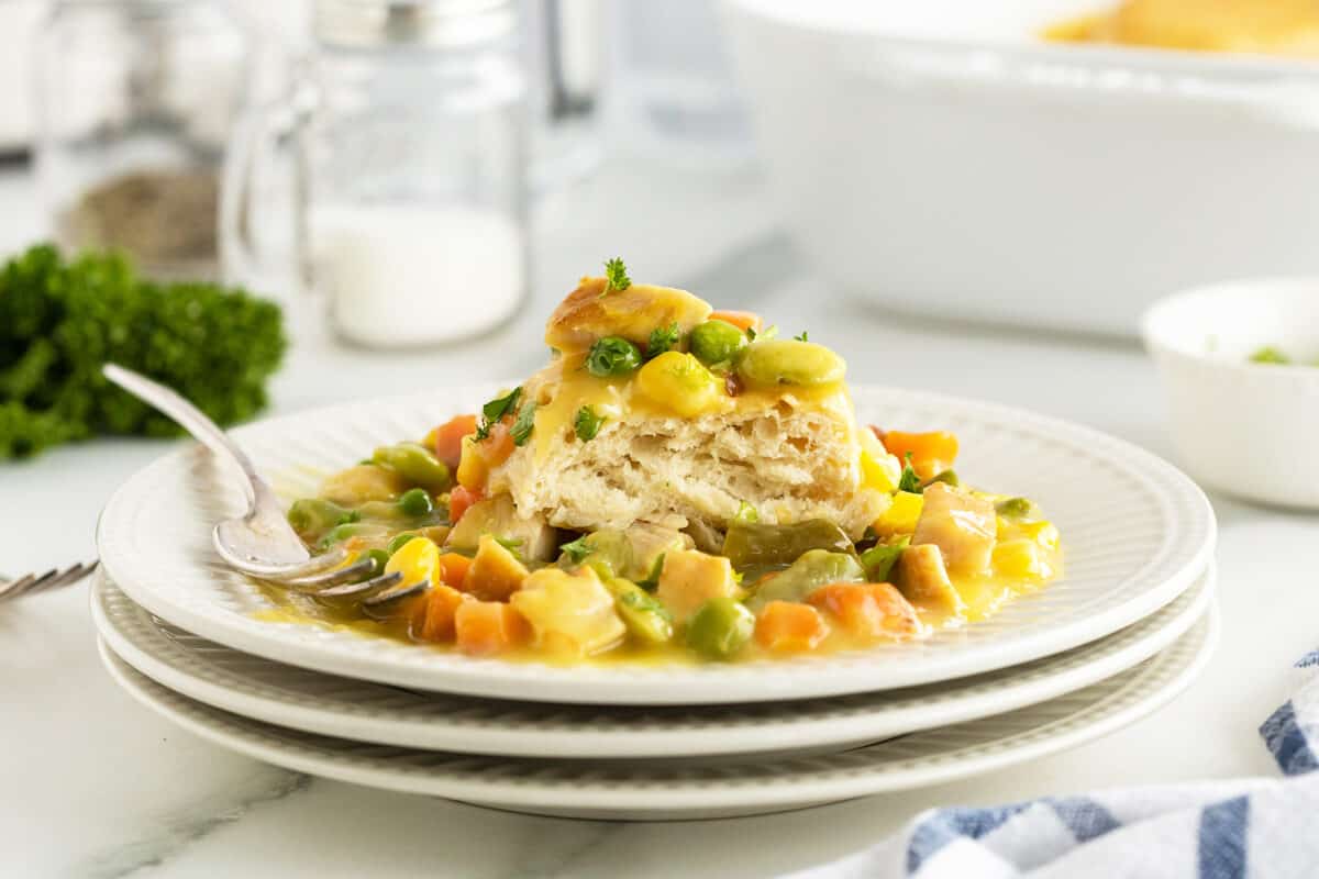 chicken pot pie casserole on a stack of white plates with a fork
