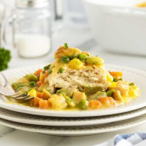 chicken pot pie casserole on a stack of white plates with a fork