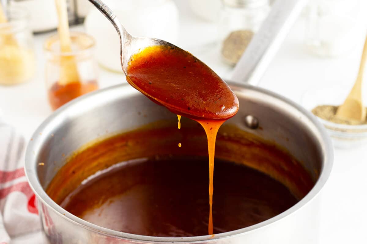 Homemade BBQ Sauce on a spoon dripping into the pot