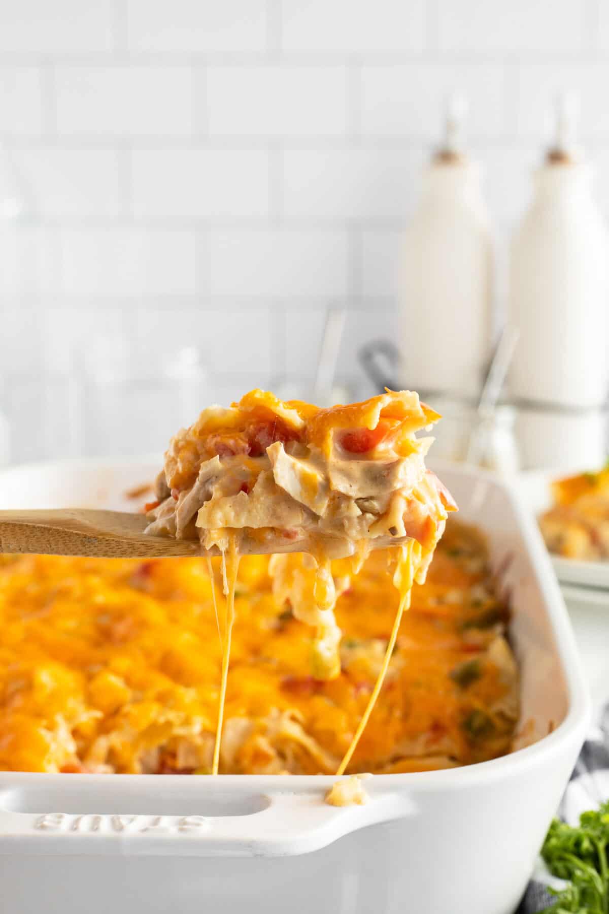 king ranch casserole in a baking pan with a slice lifed out on a spoon