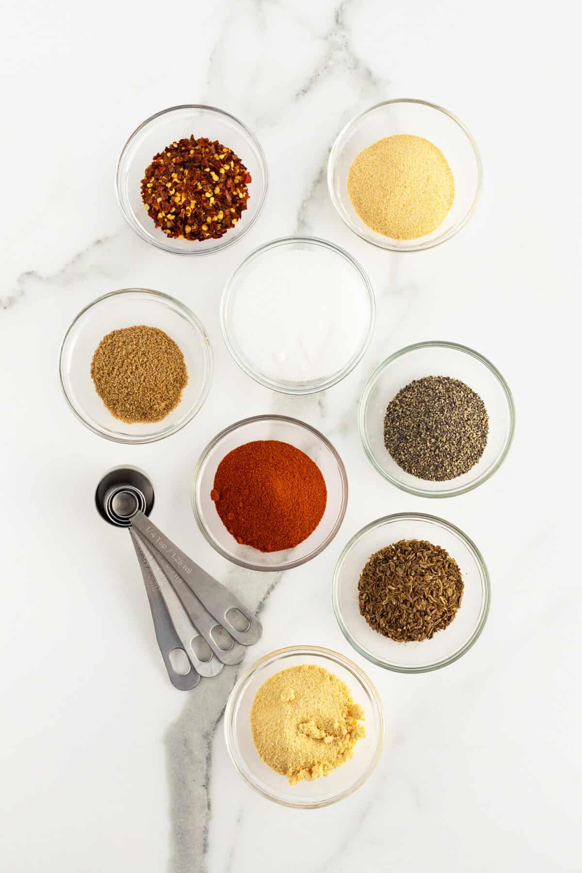 montreal steak seasoning ingredients in small clear bowls