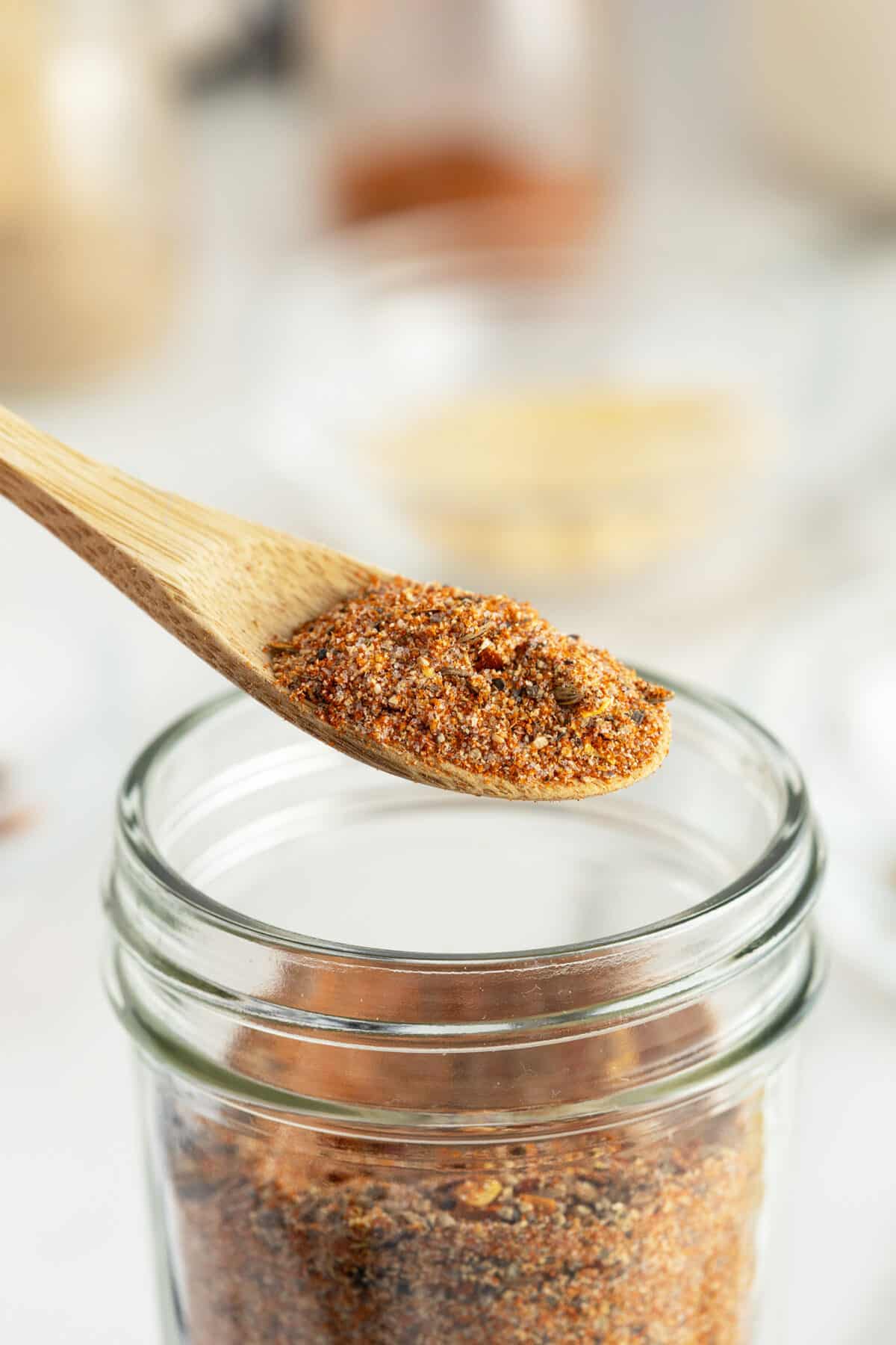 montreal steak seasoning in a jar with a wooden spoon full