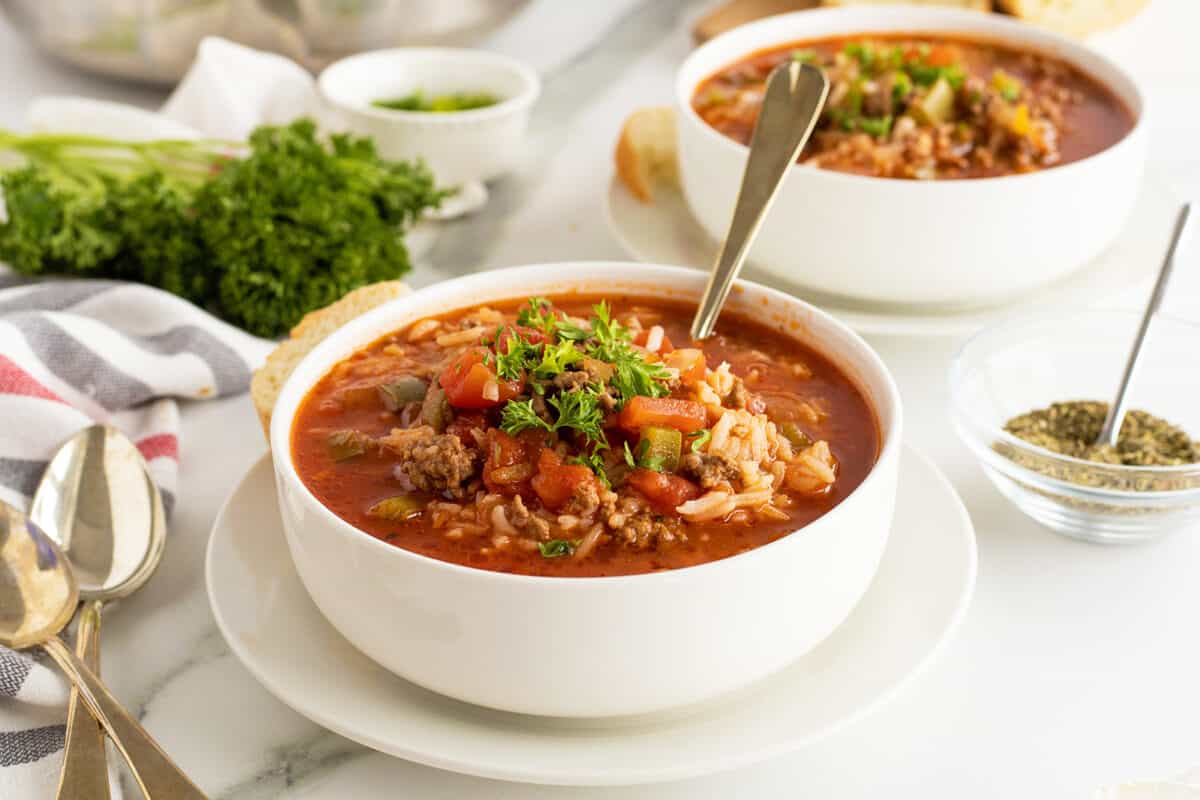 stuffed pepper soup in two white bowls with spoons