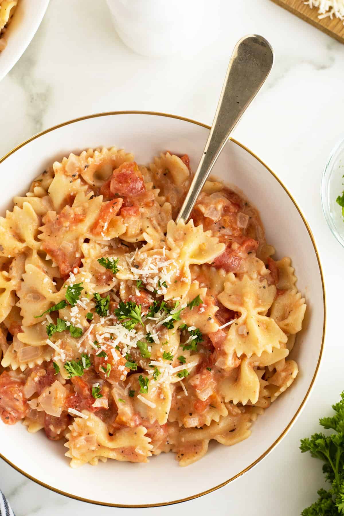 Tomato cream sauce in a bowl with pasta and garnished with parsley