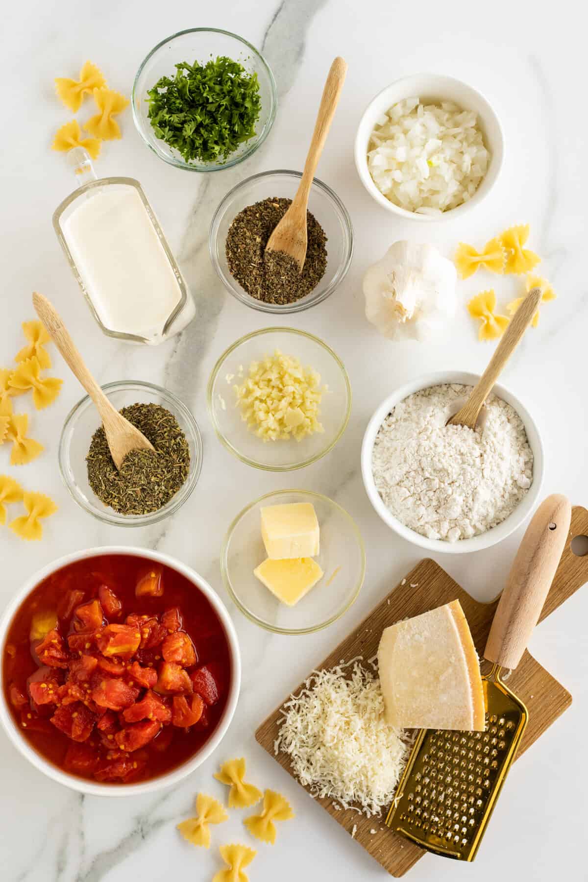 Tomato cream sauce ingredients in small clear and white bowls