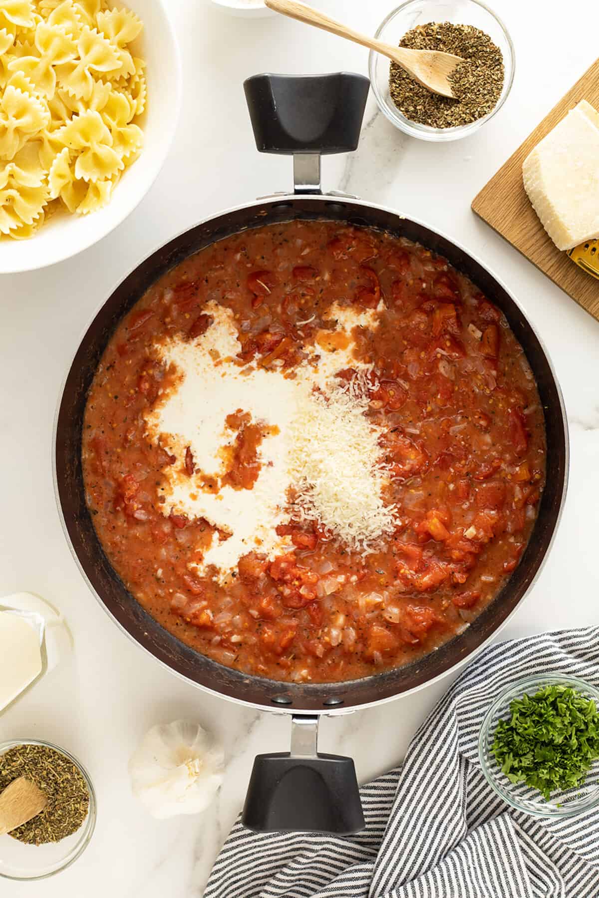 Tomato cream sauce in a pot with cream added in the center