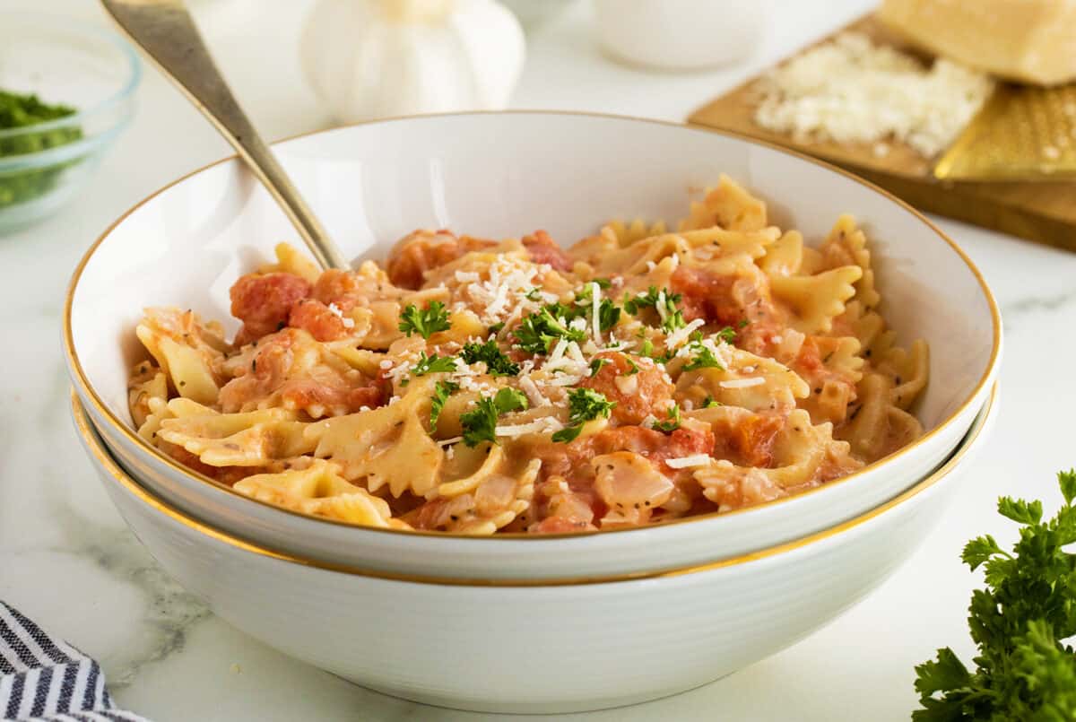 Tomato cream sauce in a white bowl with parsley garnish