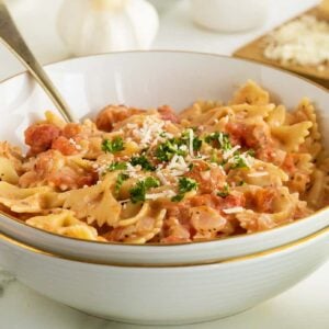 Tomato cream sauce in a white bowl with parsley garnish