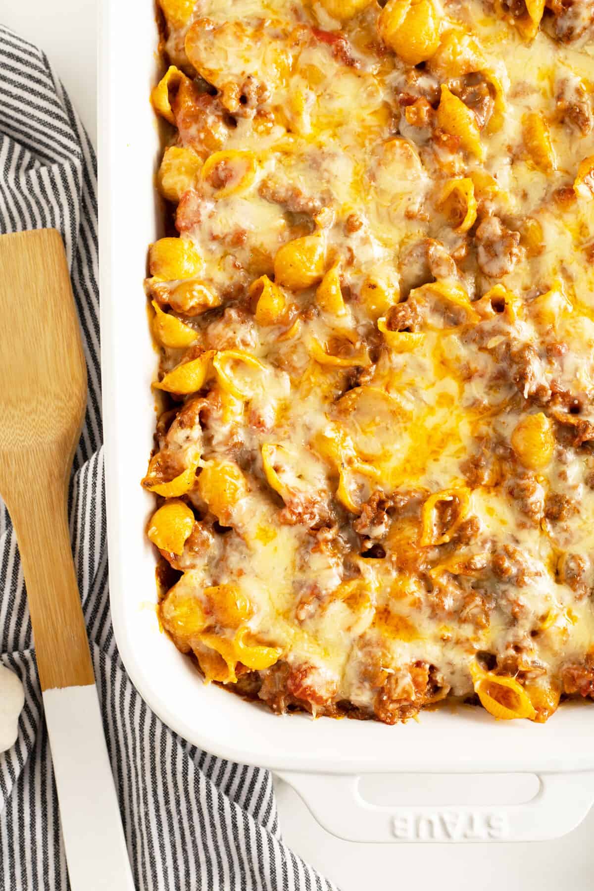 pasta bake in a white baking tray with melted cheese over the top