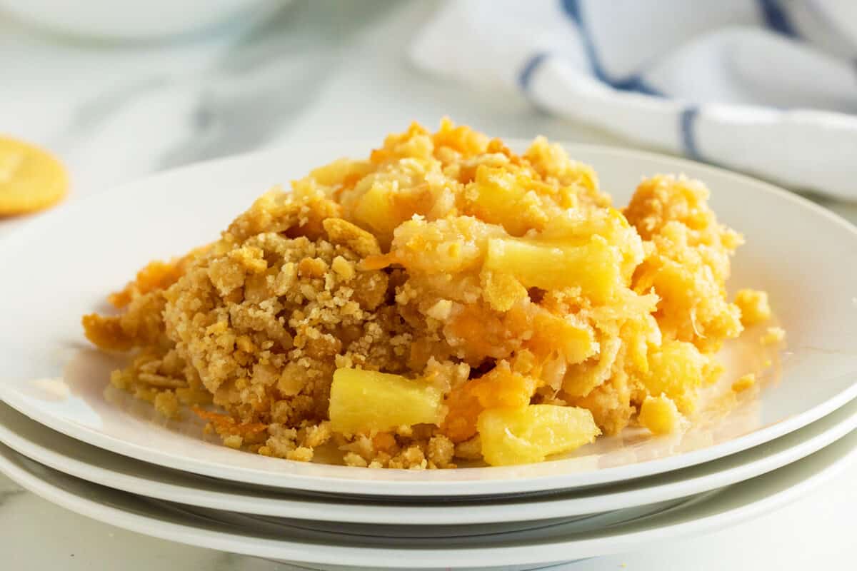 Pineapple casserole on a stack of three white plates