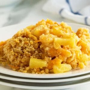 Pineapple casserole on a stack of three white plates