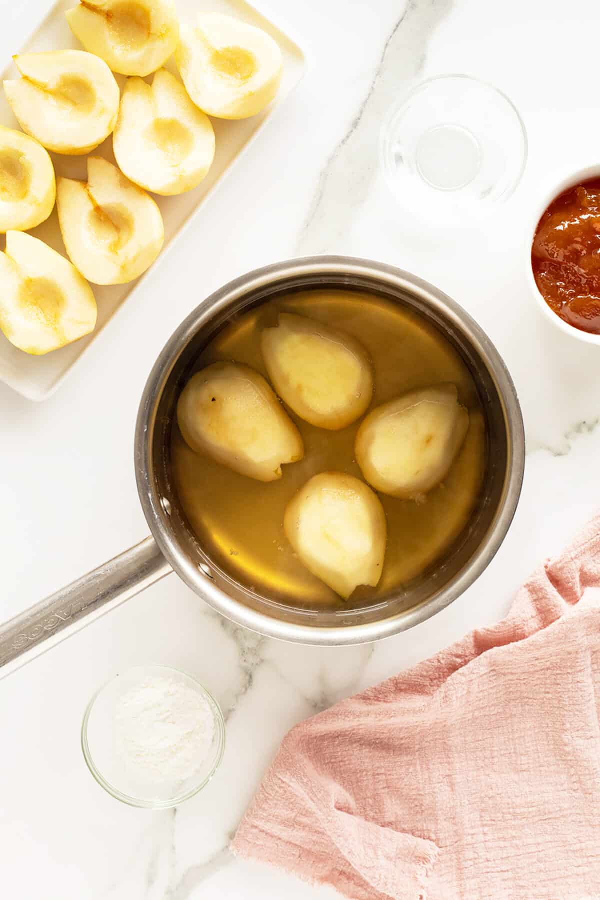 Poached pears in a pot with the sauce