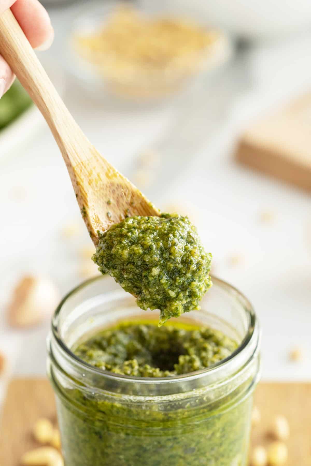 basil pesto on a large wooden spoon