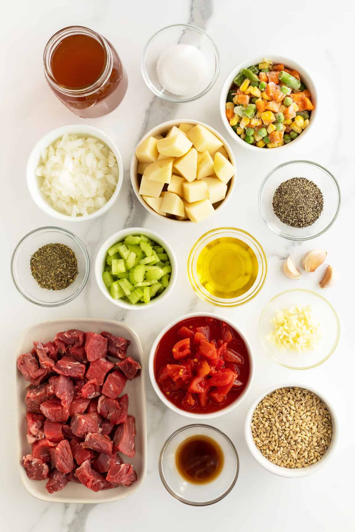 beef barley soup ingredients in small white bowls