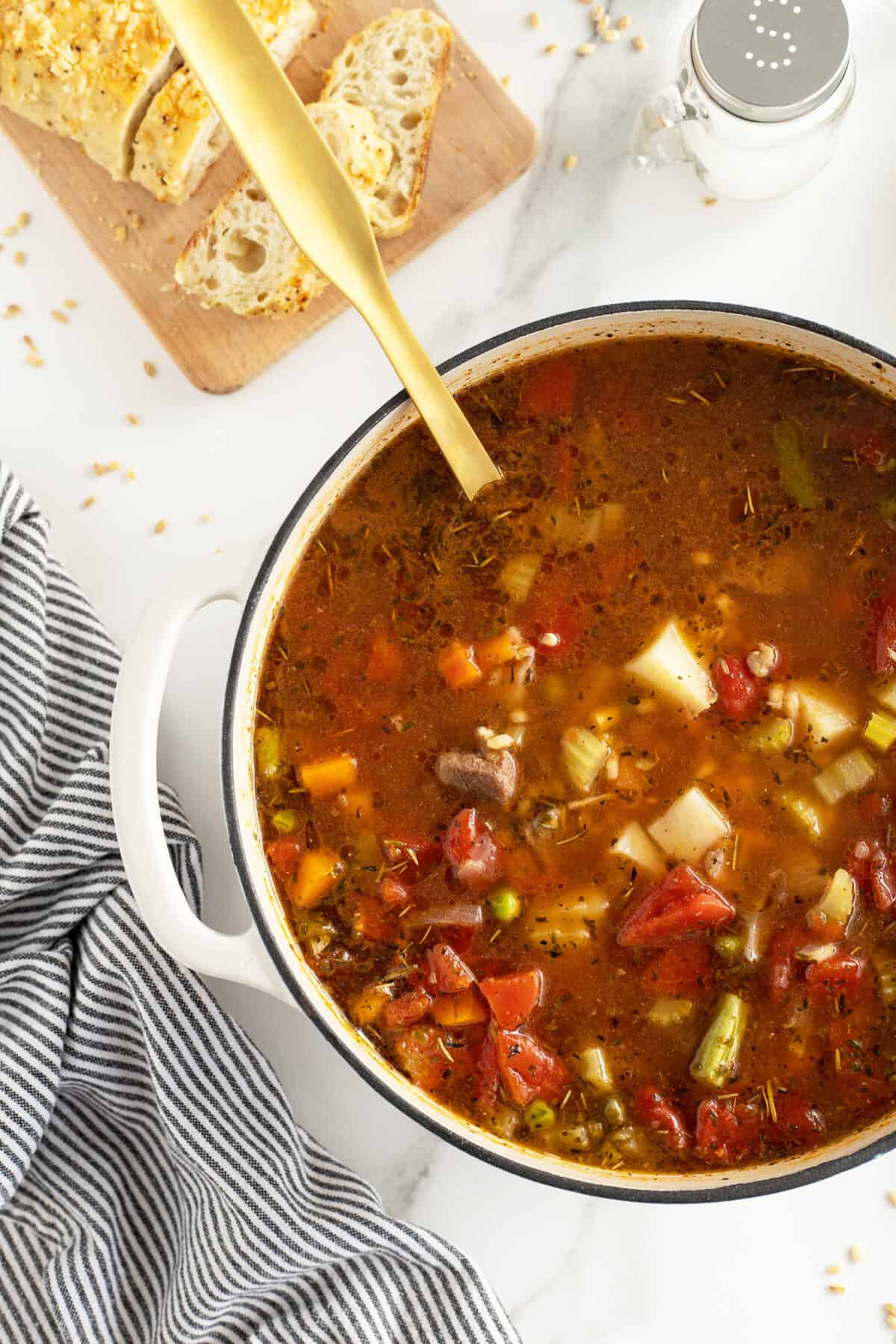 beef barley soup in a large pot with a wooden spoon in it