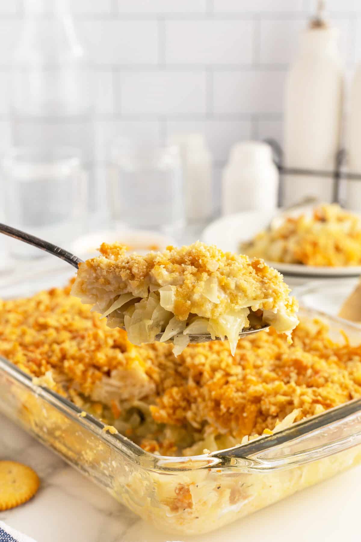 cabbage casserole loaded on a large wooden spoon over the dish