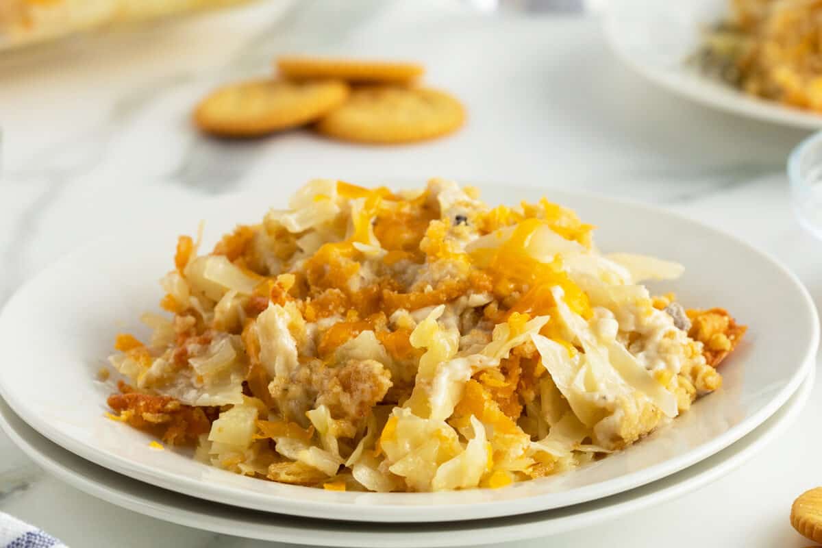 cabbage casserole on a white plate with ritz crackers in the background