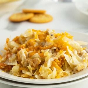 cabbage casserole on a white plate with ritz crackers in the background