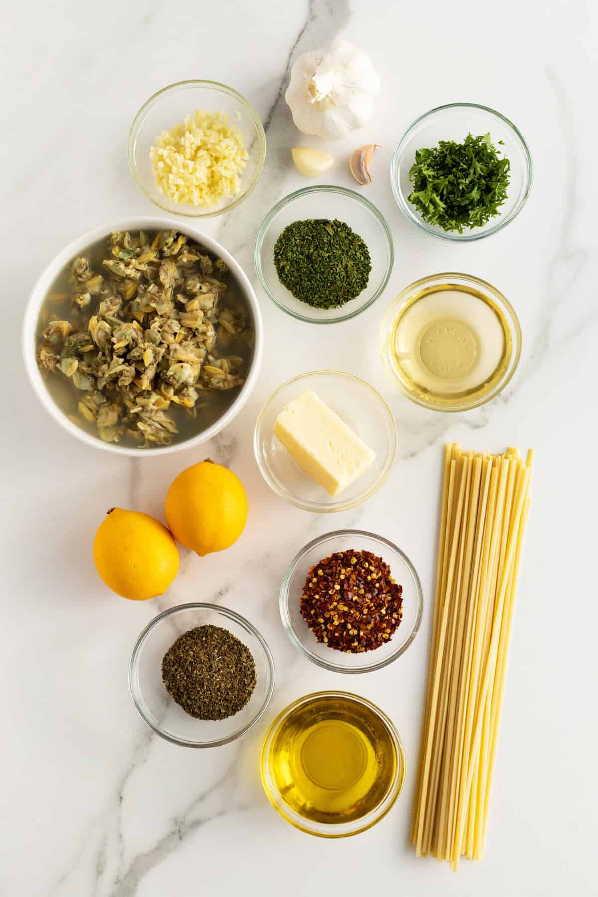 linguini with clam sauce ingredients in small clear bowls