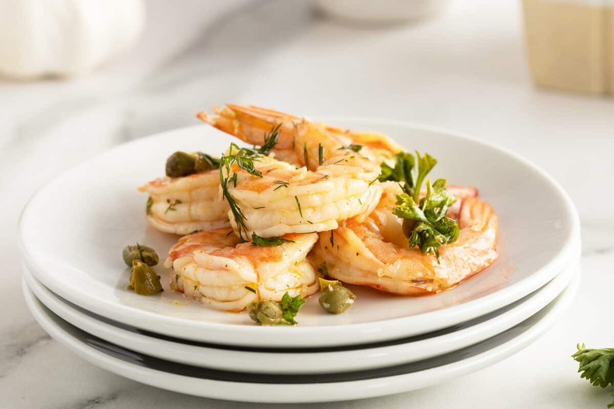 pickled shrimp on a stack of white plates
