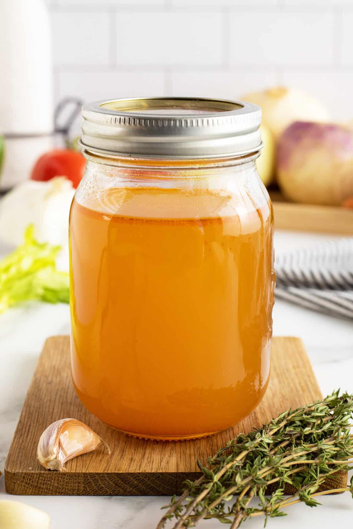 vegetable broth in a mason jar with lid on top sitting on a cutting board