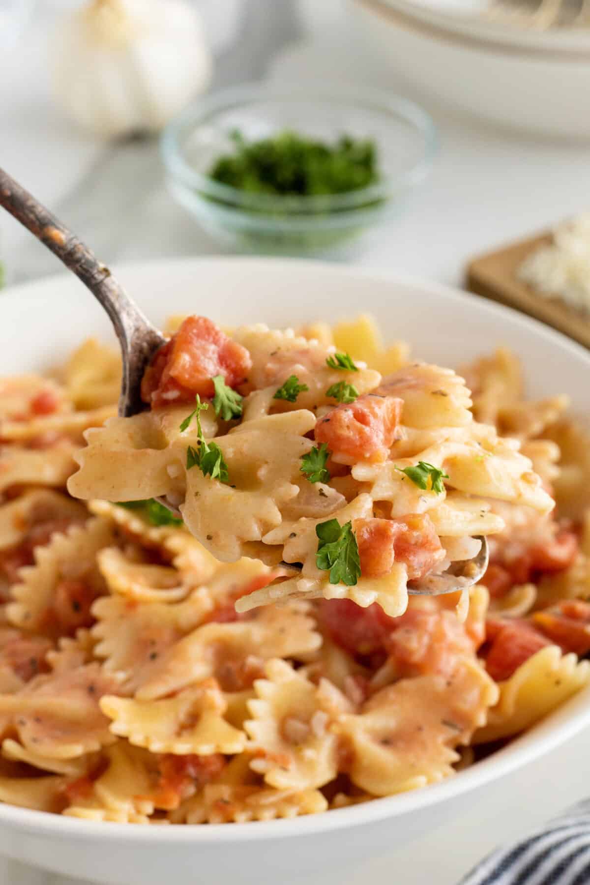 Tomato cream sauce with bowtie pasta and parsley garnish