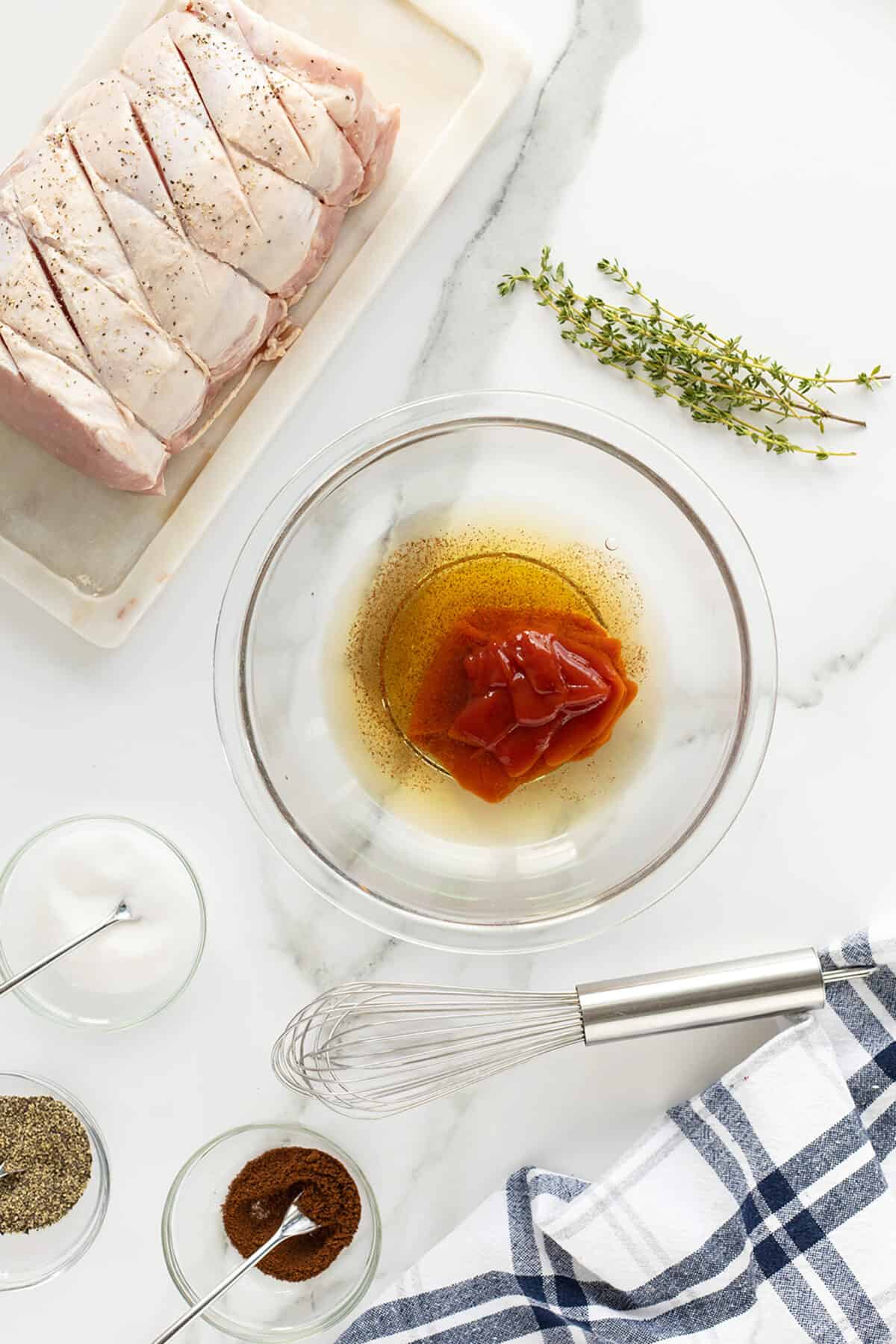 Grilled pork loin with a clear bowl with the glaze ingredients unstirred