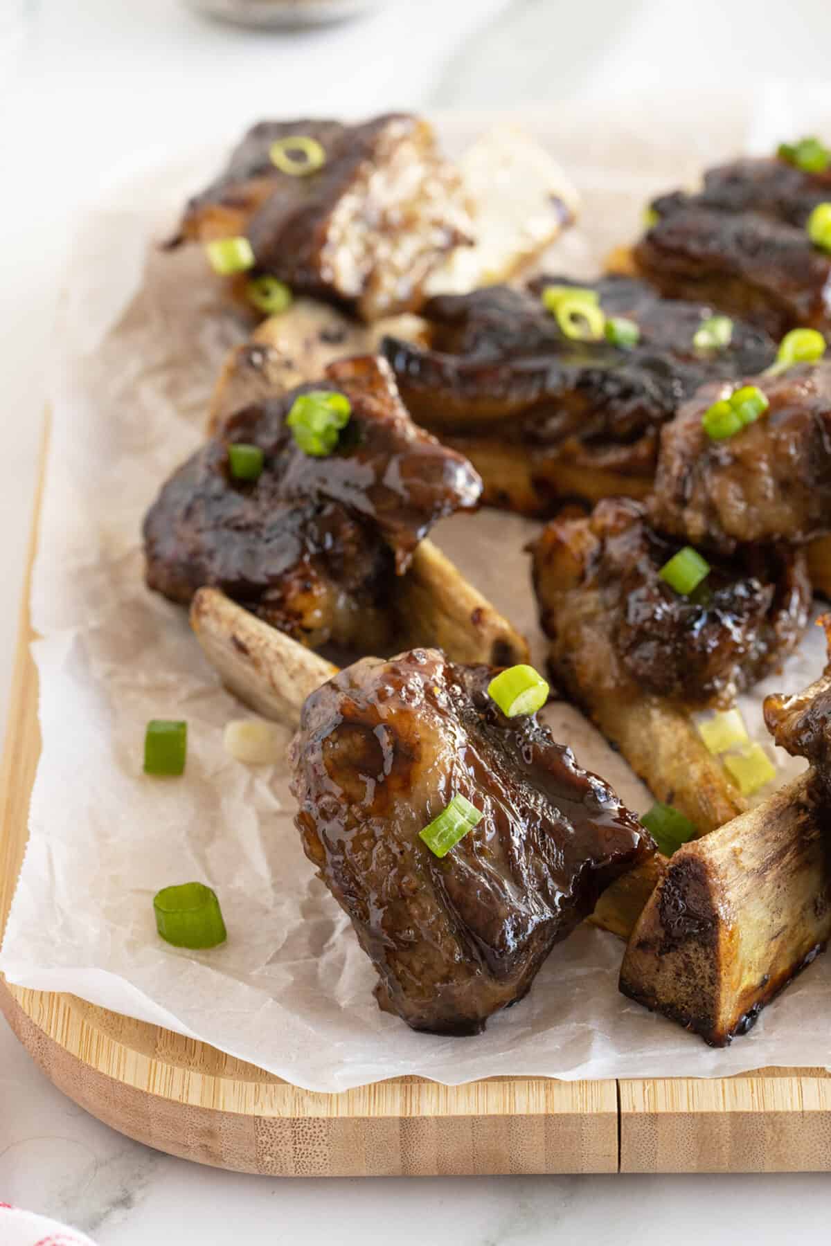 beer glazed beef ribs on parchment paper on a cutting board