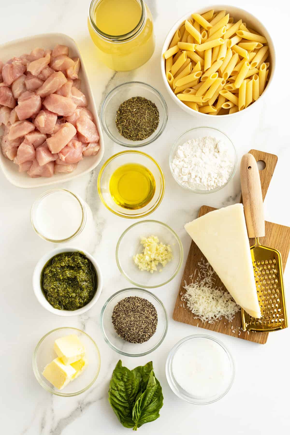 creamy chicken pesto pasta ingredients in small clear bowls