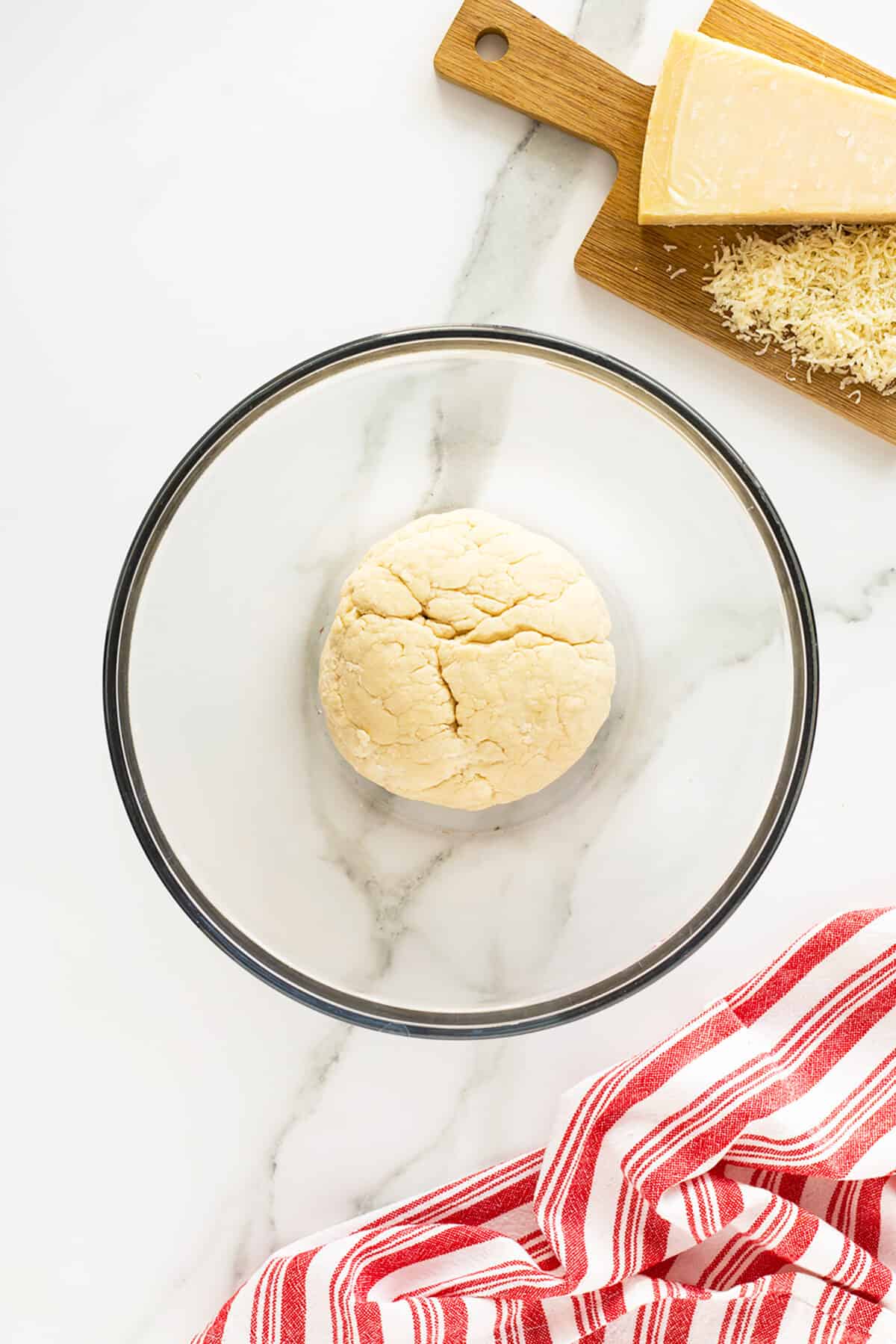 homemade breadsticks dough in a clear bowl
