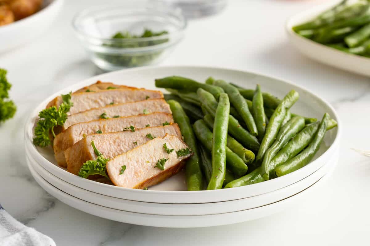 Kentucky bourbon grilled pork chops on a white plate with green beanns