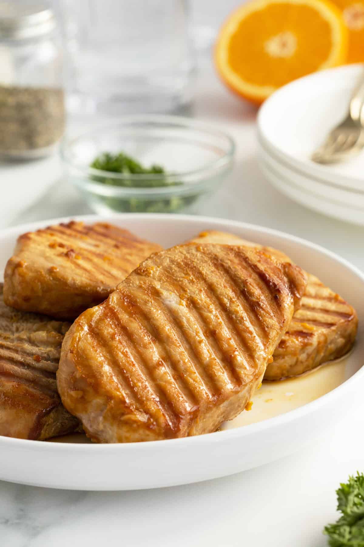 Kentucky bourbon grilled pork chops piled on a white plate