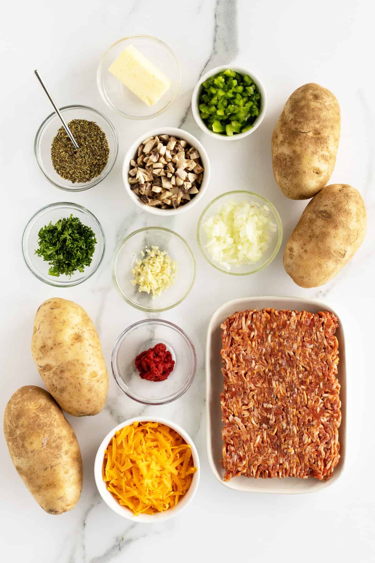 sausage stuffed potatoes ingredients in small clear bowls 