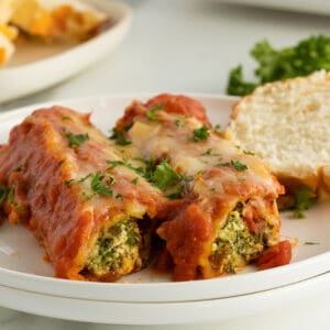 sausage stuffed manicotti On a plate with a slice of bread