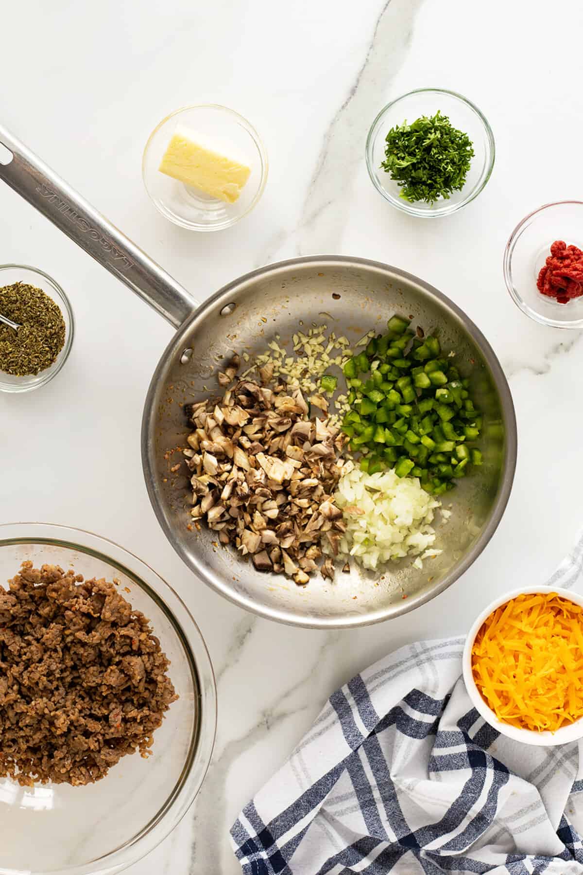 sausage stuffed potatoes vegetable ingredients in a pan