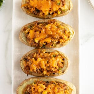 sausage stuffed potatoes on a rectangular white plate