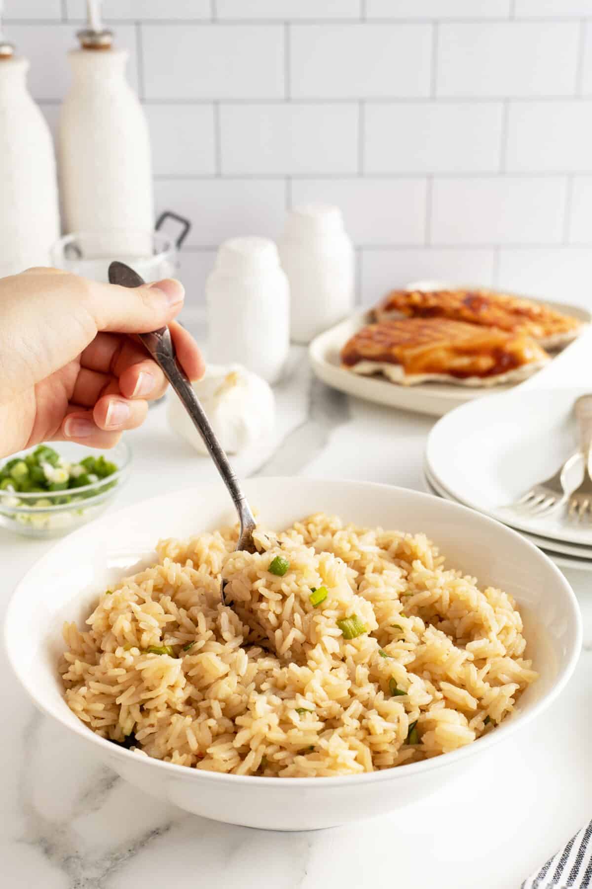 Teriyaki rice in a bowl with a spoon being lifted