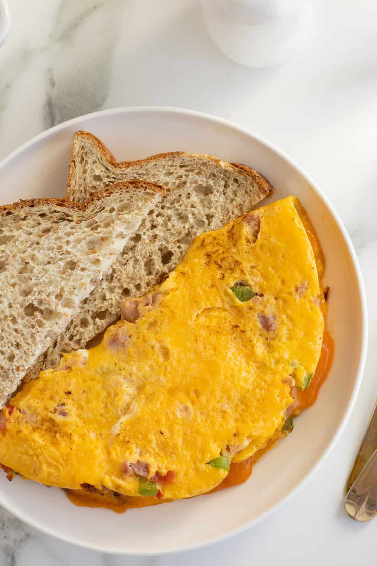 Denver omelet on a plate with a slice of toast