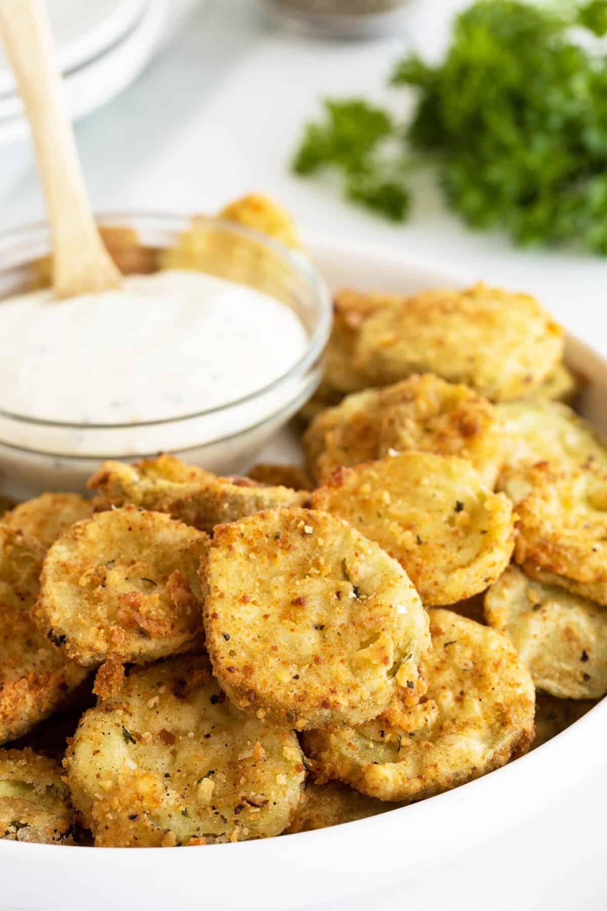 fried pickles closeup with a bowl of dip