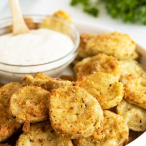 fried pickles closeup with a bowl of dip