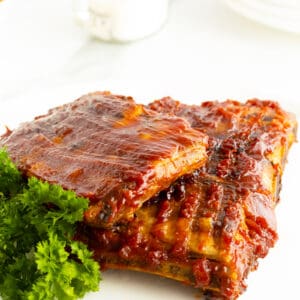 glazed spareribs unsliced on a plate with parsley