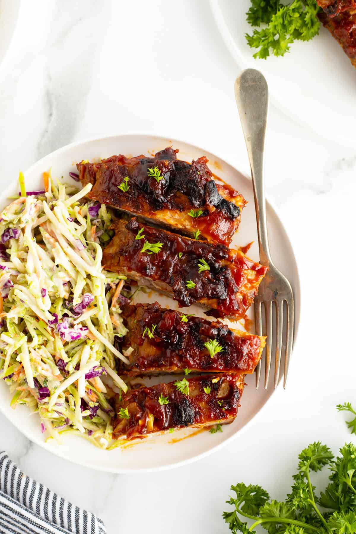 glazed spareribs sliced on a plate with sole slaw
