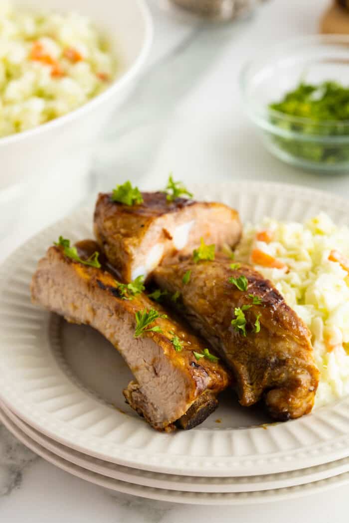honey mustard glazed ribs sliced and stacked on a white plate